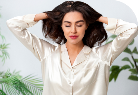 A woman with thick, healthy hair running her hands through it, illustrating the follicular stimulation and hair growth benefits of PRF hair restoration.