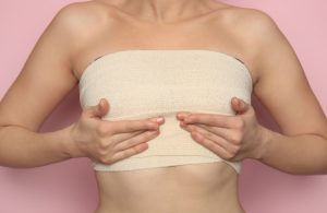 Woman showing post-procedure bandaging after a Breast Lift with BodyTite treatment.