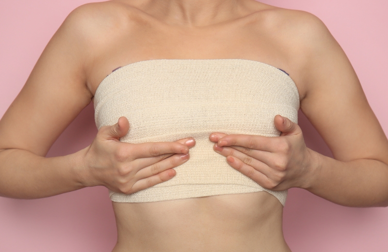 Woman showing post-procedure bandaging after a Breast Lift with BodyTite treatment.